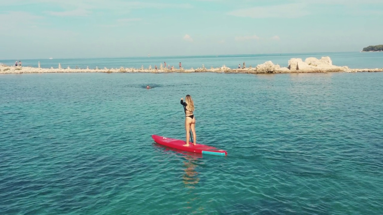 站起来划桨看风景，女人在大海中央SUP视频素材