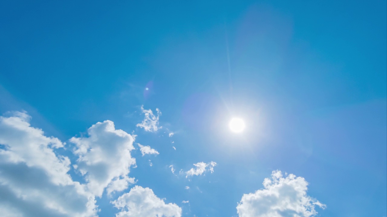 明亮的太阳光线耀斑n阳光通过彩色的深色积云在美丽的阳光柔和的蓝色天空在热带夏天阳光n阳光在白天阳光日，4k b-roll time elapse视频素材