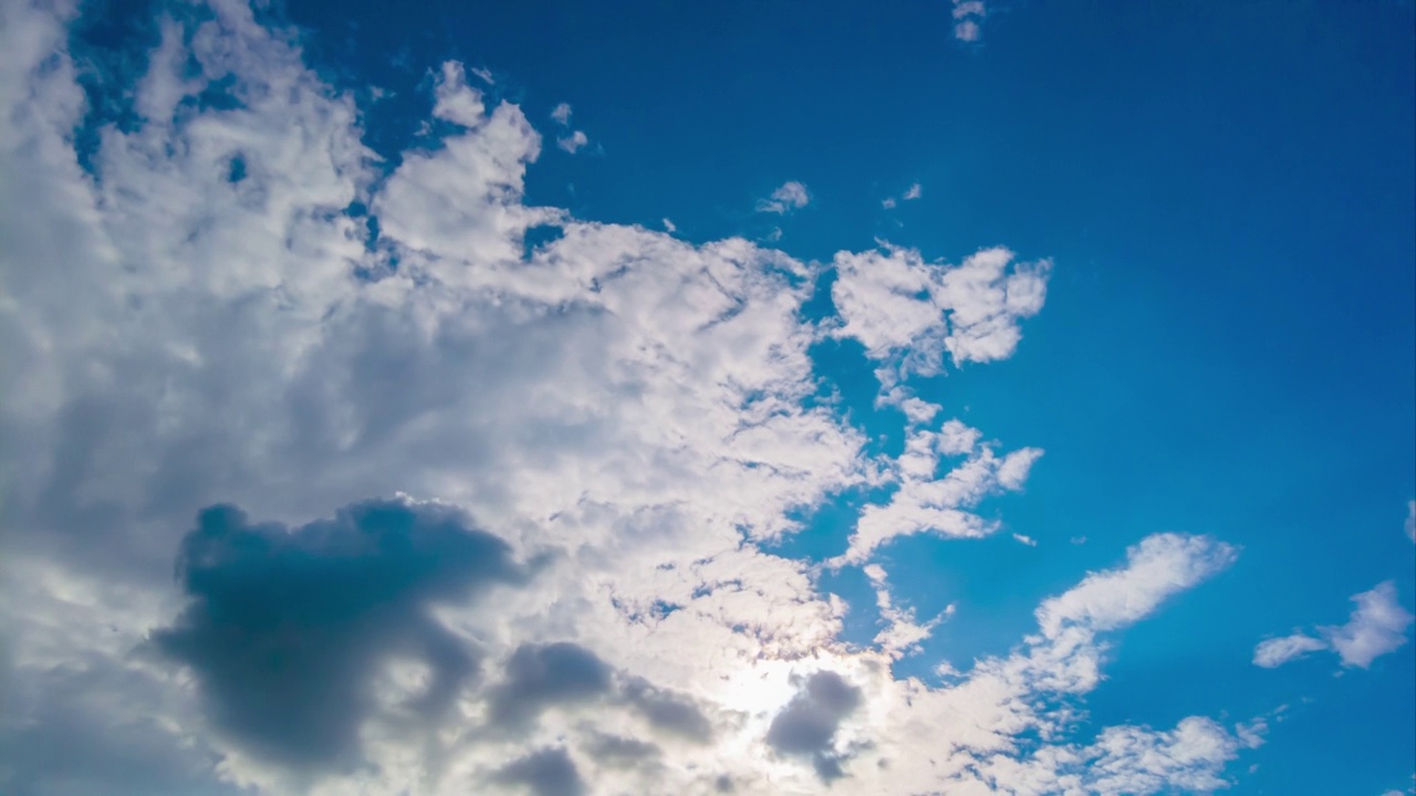 开阔的天空云团棉花云背景蓝色户外移动云团旋转向上。云在陆地上湛蓝的天空中快速移动和变换。时光流逝云美丽天空视频素材