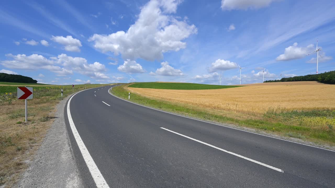 夏天有风力涡轮机的乡村道路视频素材