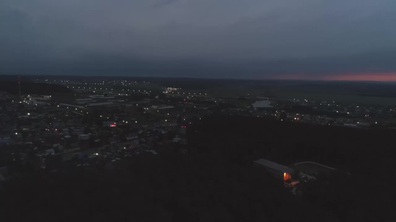 夜村鸟瞰图。闪电在天空中闪烁视频下载