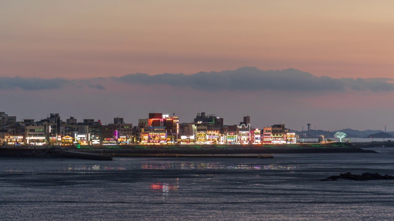 退潮时，韩国京畿道始兴市黄海附近的大岛岛，生命之树天文台和市中心的夜景视频素材