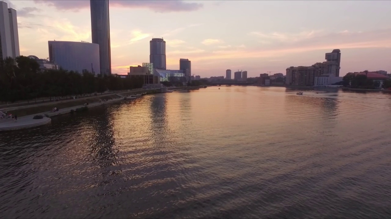 日落时，天空映衬下城市中的河流的航拍视频下载