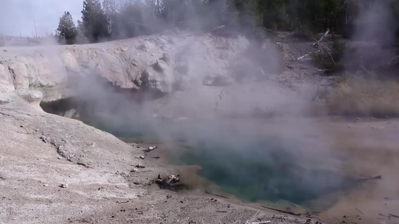 蒸青绿色的温泉和洞穴口。黄石公园诺里斯间歇泉盆地。视频素材