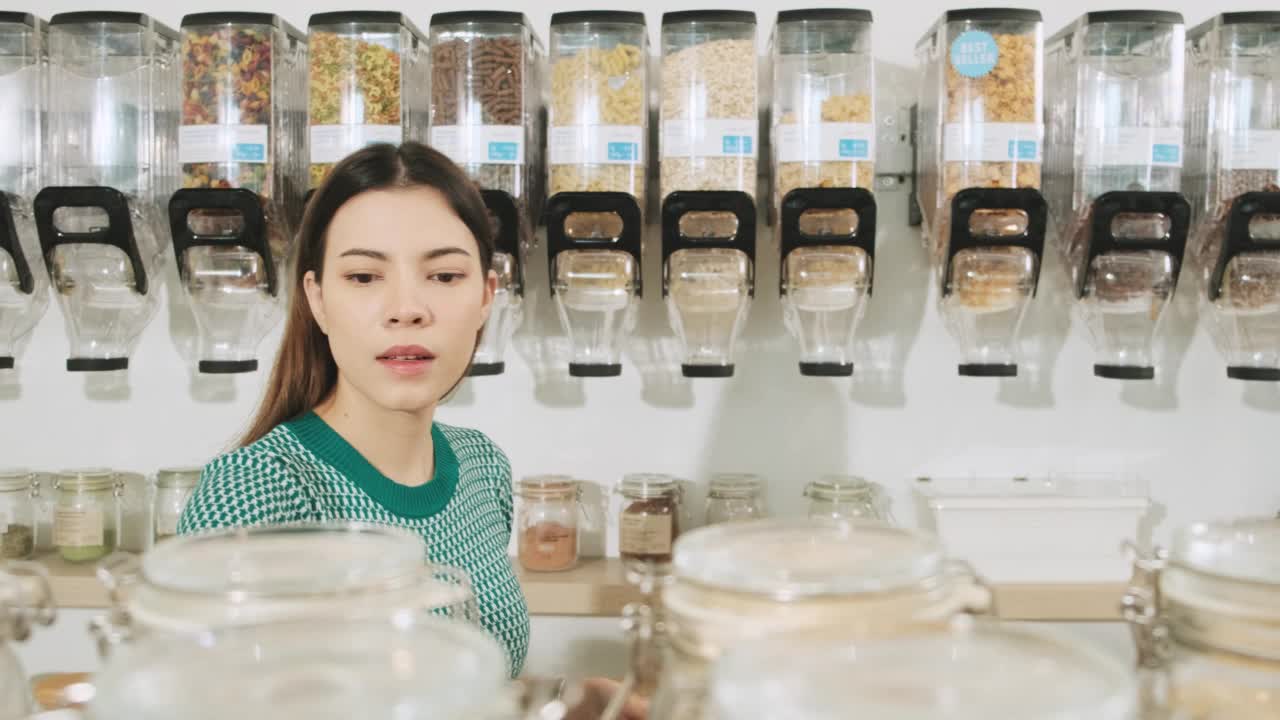 一名年轻女子在购物商店用可重复使用的袋子，零废物杂货。视频素材