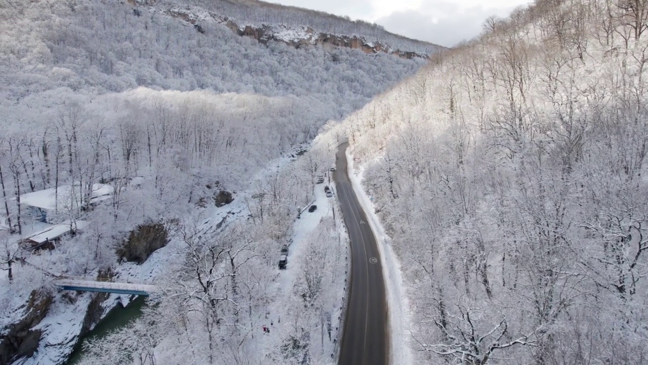 高原鸟瞰图拉古-纳基山扭曲的道路在冬天和驾驶汽车。史诗，白雪覆盖的冬天和雪林。视频下载