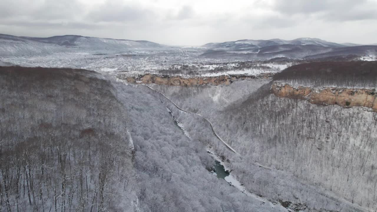 高原鸟瞰图拉古-纳基山扭曲的道路在冬天和驾驶汽车。史诗，白雪覆盖的冬天和雪林。视频素材