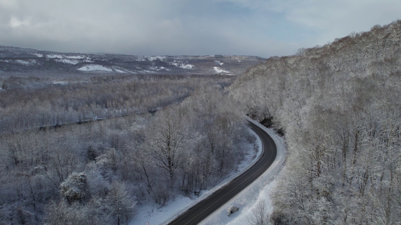 高原鸟瞰图拉古-纳基山扭曲的道路在冬天和驾驶汽车。史诗，白雪覆盖的冬天和雪林。视频素材