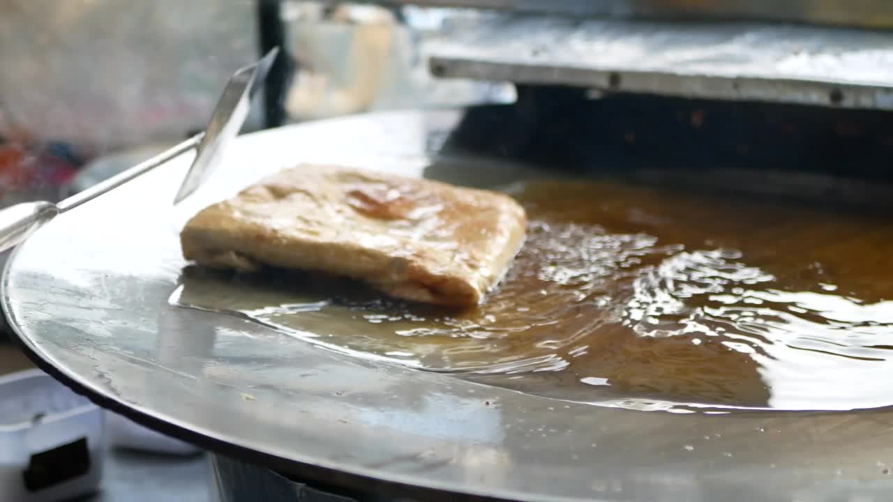 食品小贩制作著名的马来西亚(印尼)食物，称为鸡蛋马尔塔巴克。Martabak是马来西亚(印尼)人喜爱的外卖食品。制作Martabak的过程。视频素材