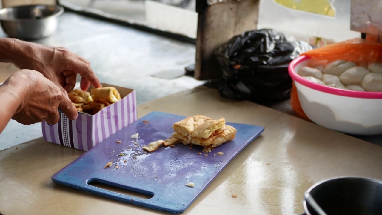 食品小贩制作著名的马来西亚(印尼)食物，称为鸡蛋马尔塔巴克。Martabak是马来西亚(印尼)人喜爱的外卖食品。制作Martabak的过程。视频素材