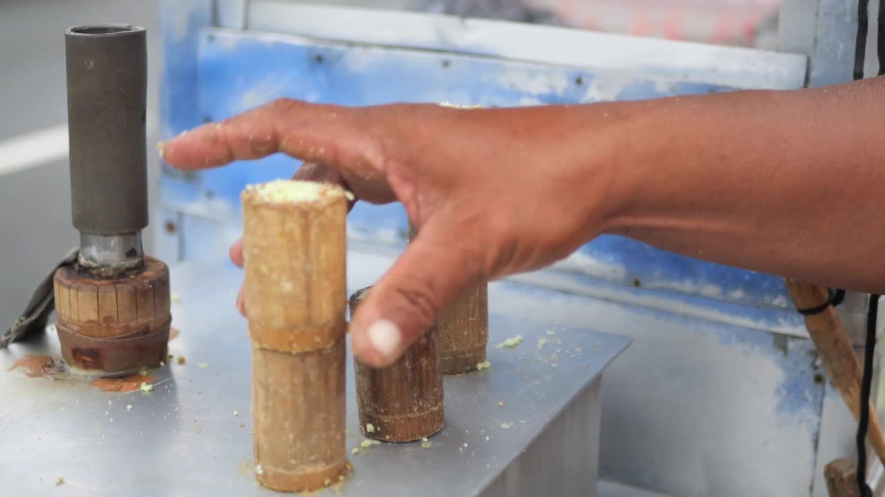 制作印尼传统小吃摊kue putu bambu的过程。用米粉和竹制模具成型。烹饪的汽笛声和香兰的香气很有特色。视频素材