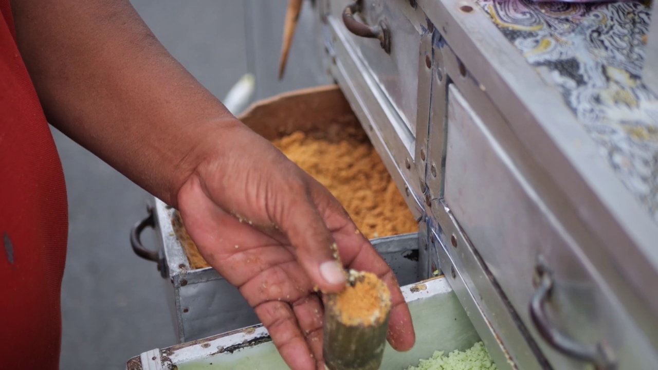 制作印尼传统小吃摊kue putu bambu的过程。用米粉和竹制模具成型。烹饪的汽笛声和香兰的香气很有特色。视频素材