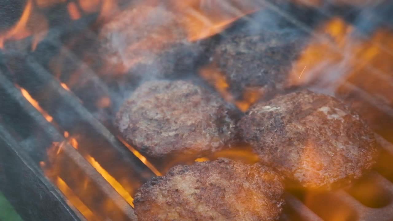 在烤架上煎汉堡肉。在外面野餐。肉是烤的。烧烤架。视频素材