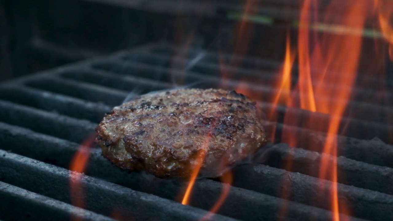 在烤架上煎汉堡肉。在外面野餐。肉是烤的。烧烤架。视频素材