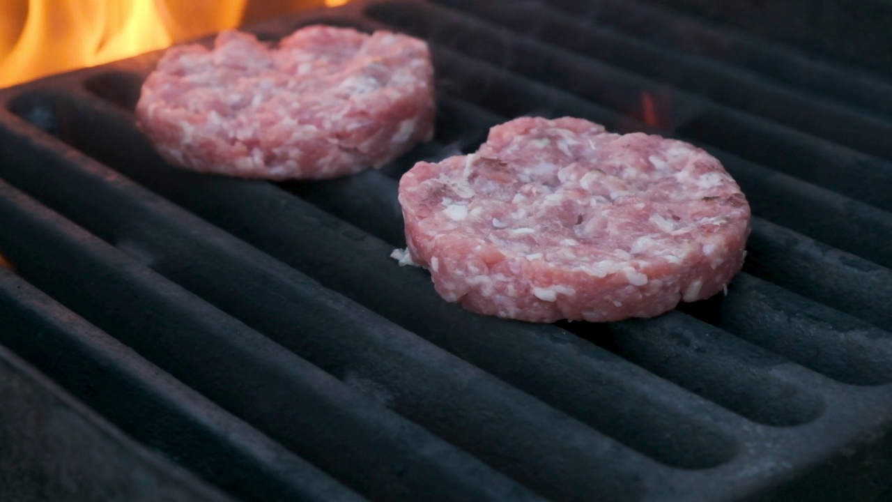 男人在烤架上烤肉，把多汁的生肉放在热烤架上做汉堡视频素材