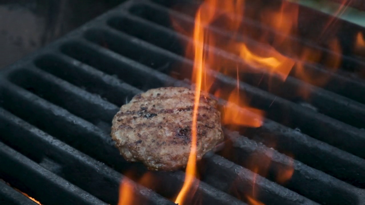 在烤架上煎汉堡肉。在外面野餐。肉是烤的。烧烤架。视频素材