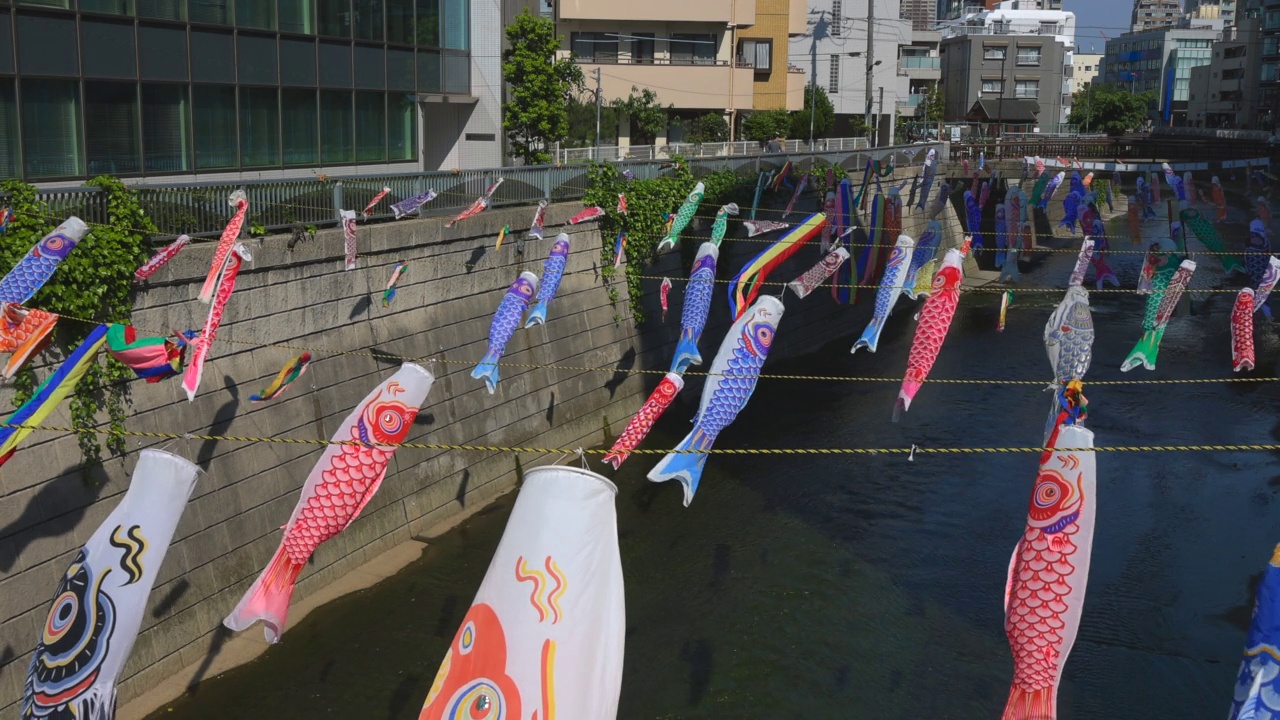 在日本东京新宿高田桥的儿童节，小inobori鲤鱼飘带在风中飘过神田河视频素材