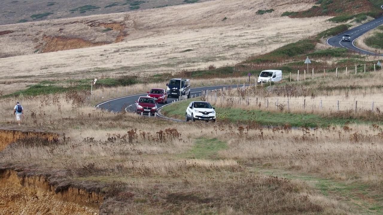 行驶在英国怀特岛康普顿湾海岸公路上的汽车。视频素材