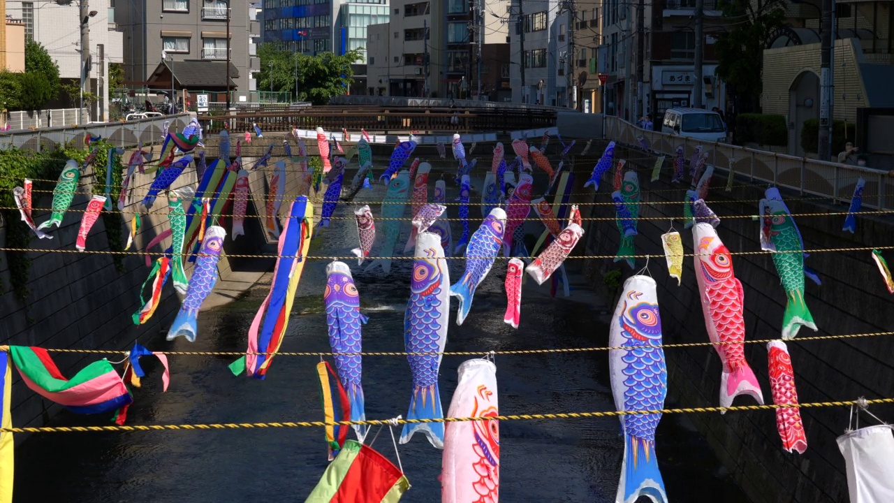 在日本东京新宿高田桥的儿童节，小inobori鲤鱼飘带在风中飘过神田河视频素材