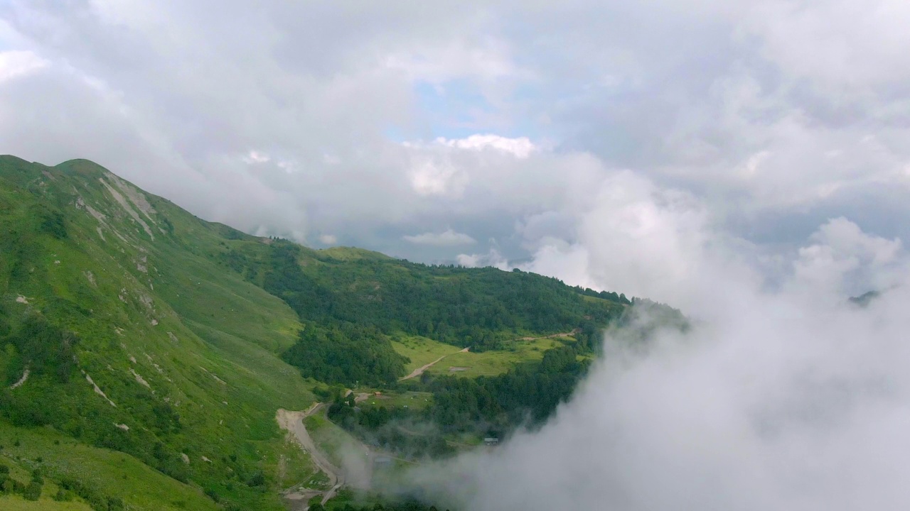 鸟瞰令人惊叹的山景。在日落时穿过云层。视频素材