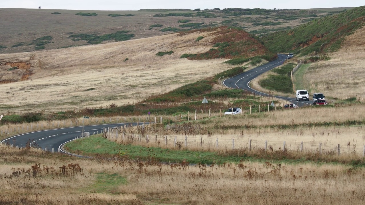 行驶在英国怀特岛康普顿湾海岸公路上的汽车。视频素材