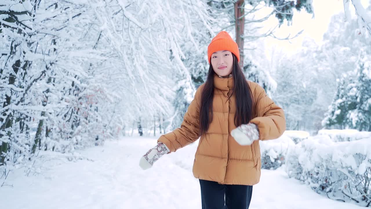 快乐快乐的年轻女子跳舞，快乐地跑下公园雪冬天寒冷的天气。幸福。亚洲女学生在雪地自然背景下微笑着跳着走。快乐,视频素材