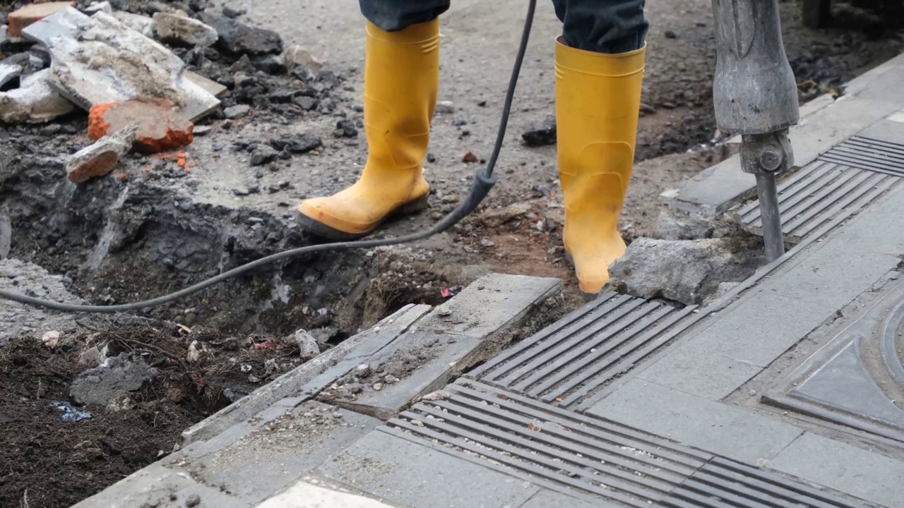 在道路施工现场使用手提钻的工人视频素材