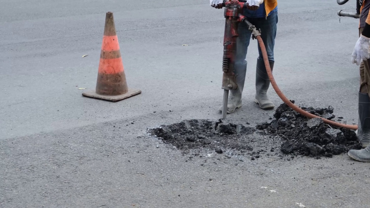 在道路施工现场使用手提钻的工人视频素材