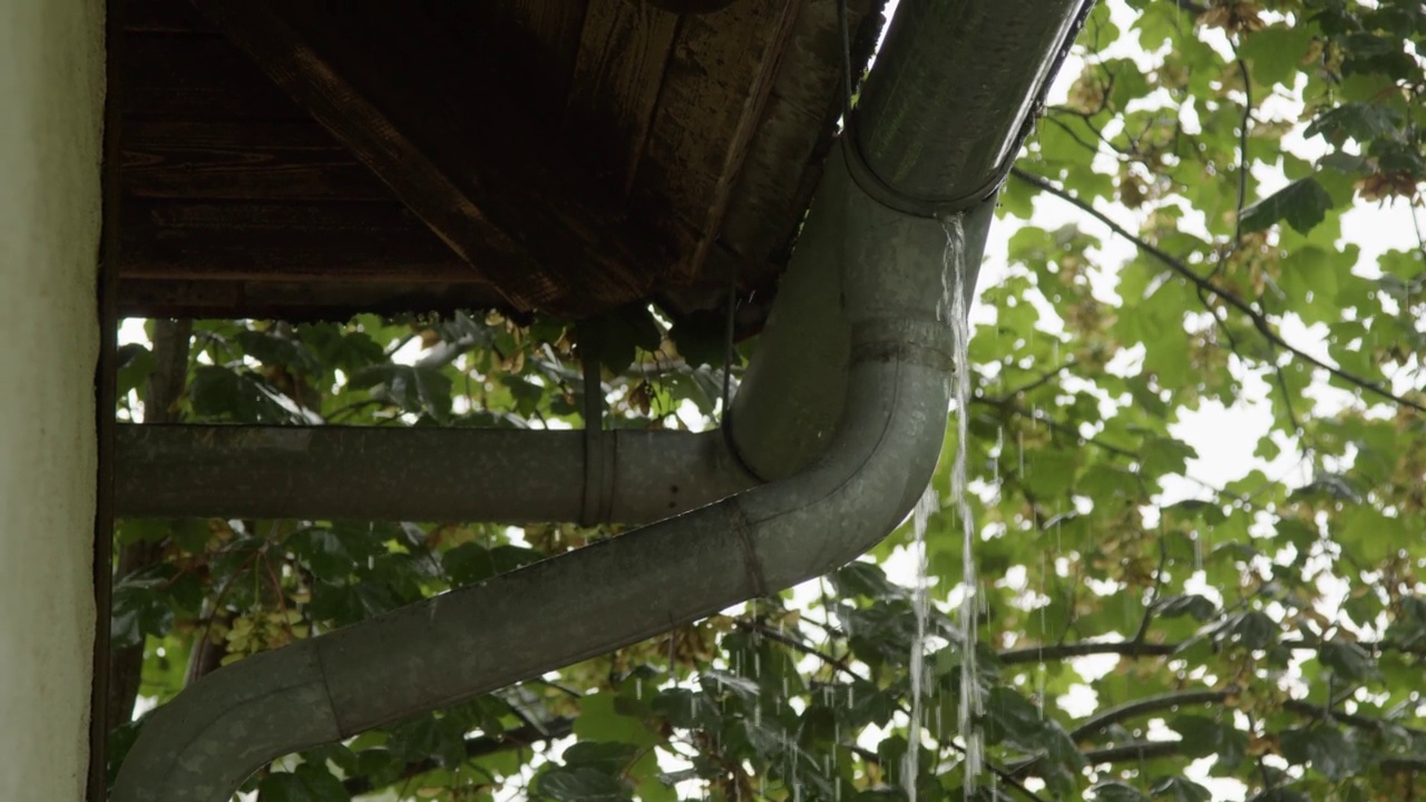 大雨从屋顶的水沟里啪嗒啪嗒地落下视频素材