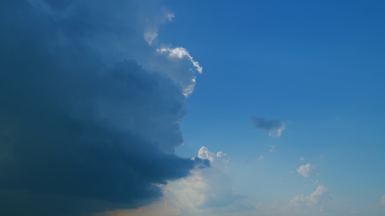 时间流逝。背景黑暗戏剧性的天空与暴风雨的云。在蓝天上飘动着白色的浮云。视频素材