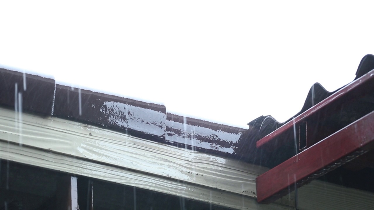 天在下雨，雨水从屋顶上倾泻而下。视频下载