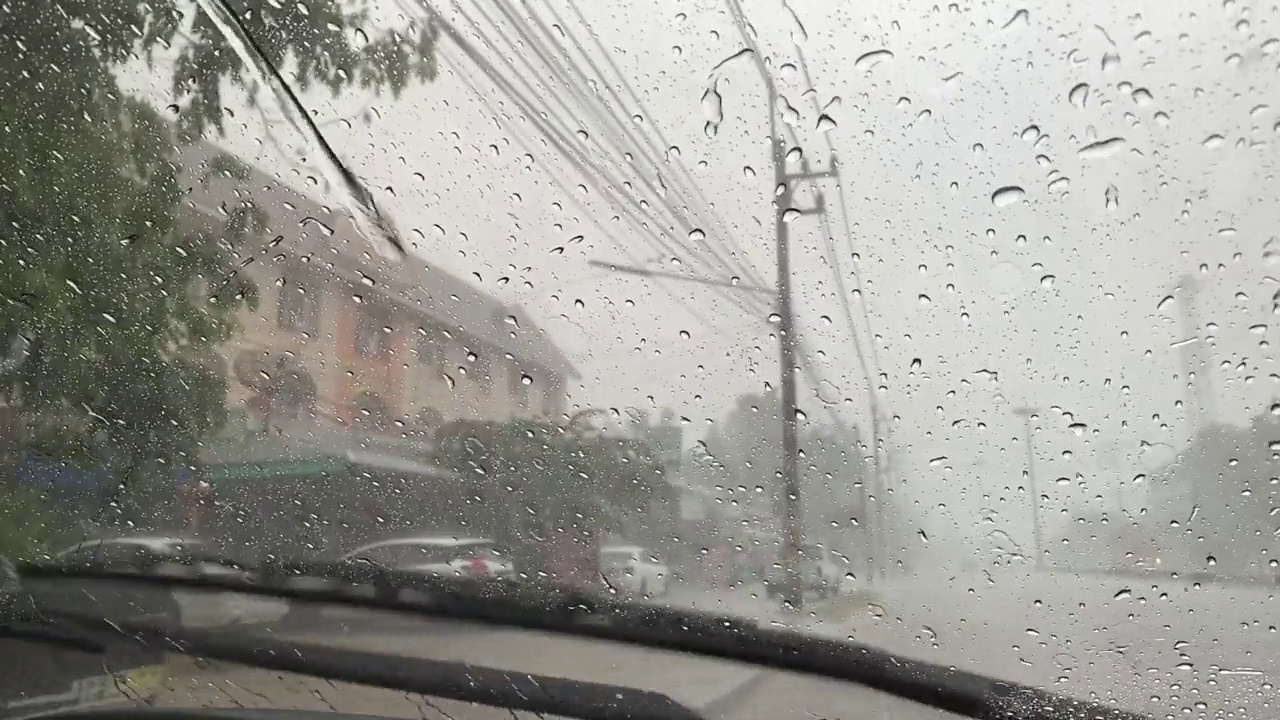 雨刷在工作，雨点落在汽车的挡风玻璃上。视频下载