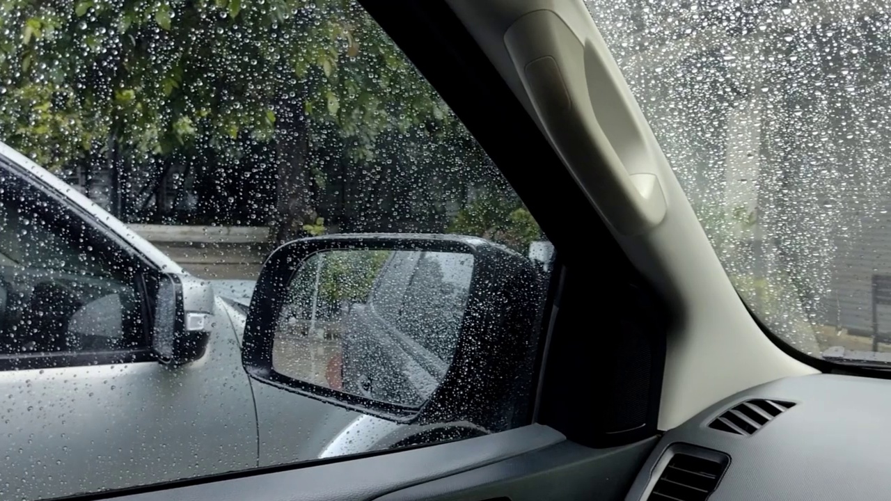 雨点和模糊离焦灯后面的雨点在草车。视频素材