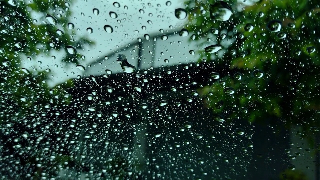 雨点和模糊离焦灯后面的雨点在草车。视频素材