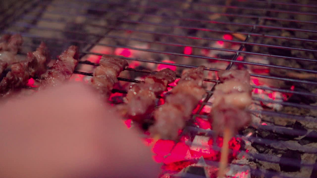 近距离的街头食品小贩正在烤烧烤牛肉串。视频素材