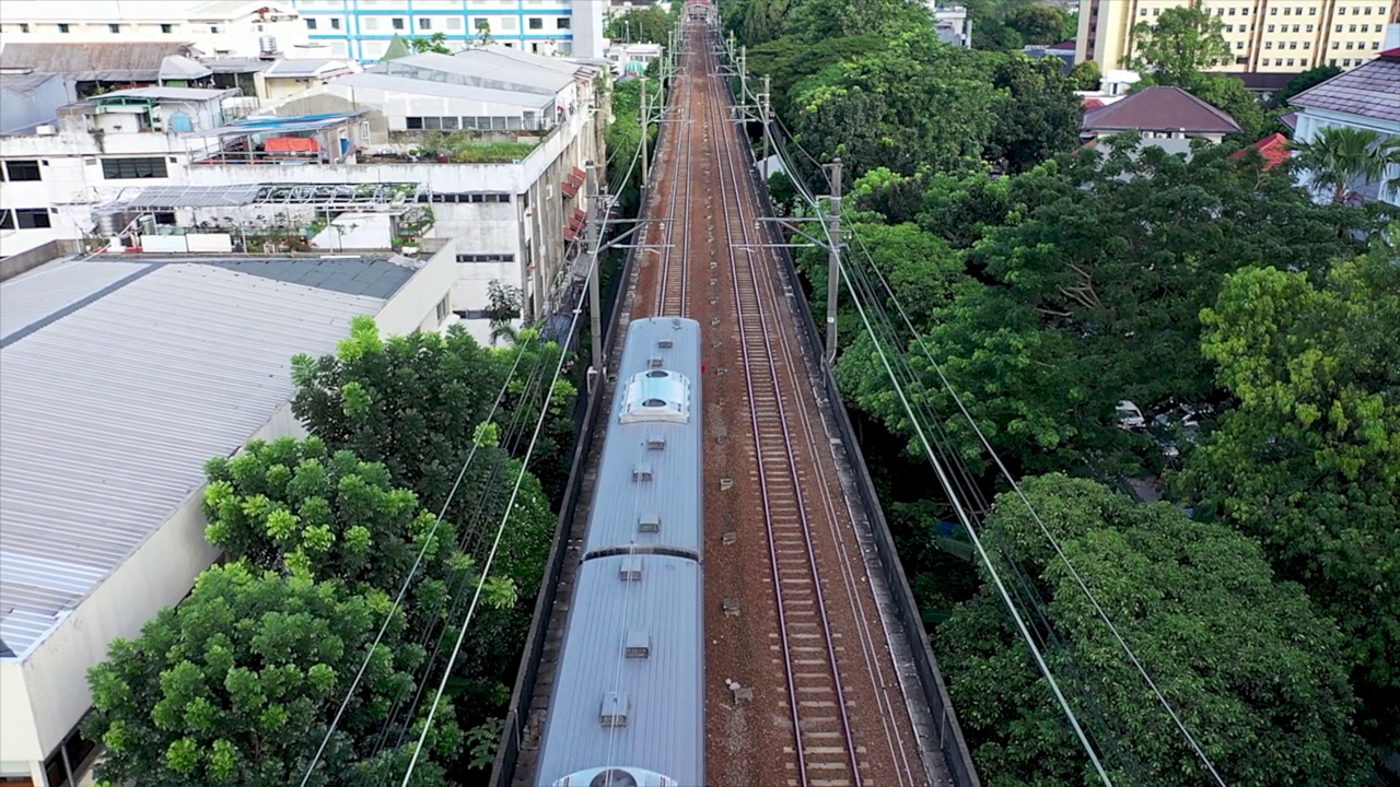 银色客运列车在运动模糊的铁路轨道上经过。空中自顶向下视图视频素材