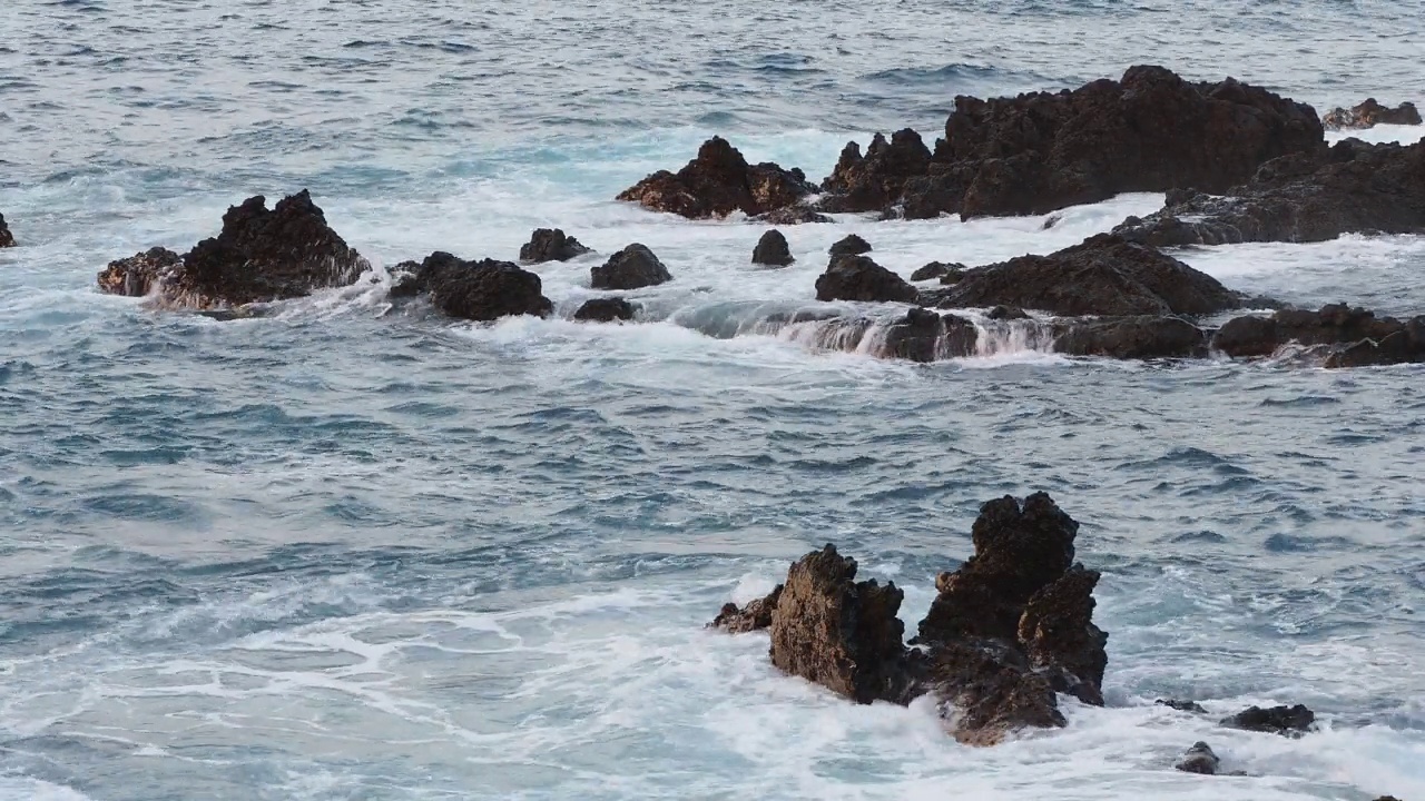 海岸景观，海浪撞击着火山岩。视频素材