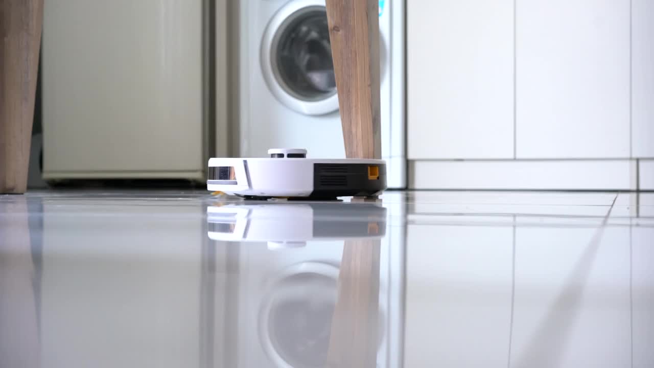 机器人吸尘器在厨房地板上工作视频素材