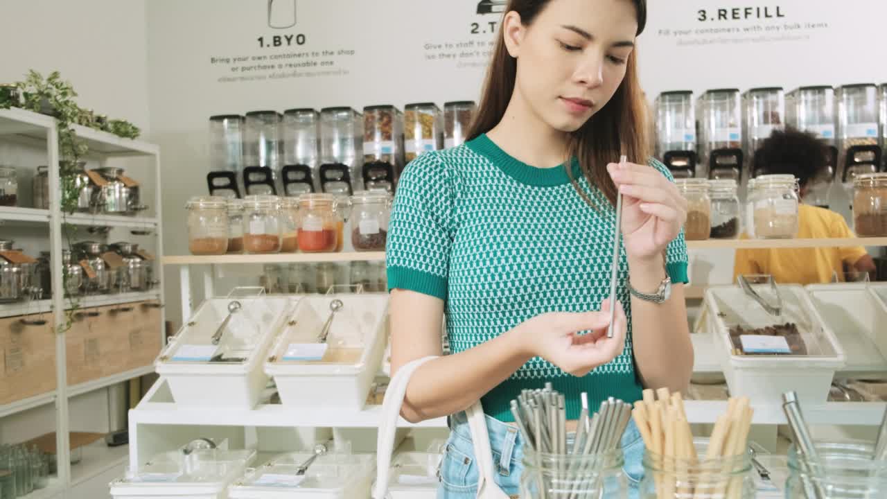 一名年轻女子在购物商店用可重复使用的袋子，零废物杂货。视频素材