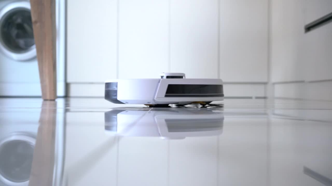 机器人吸尘器在厨房地板上工作视频素材