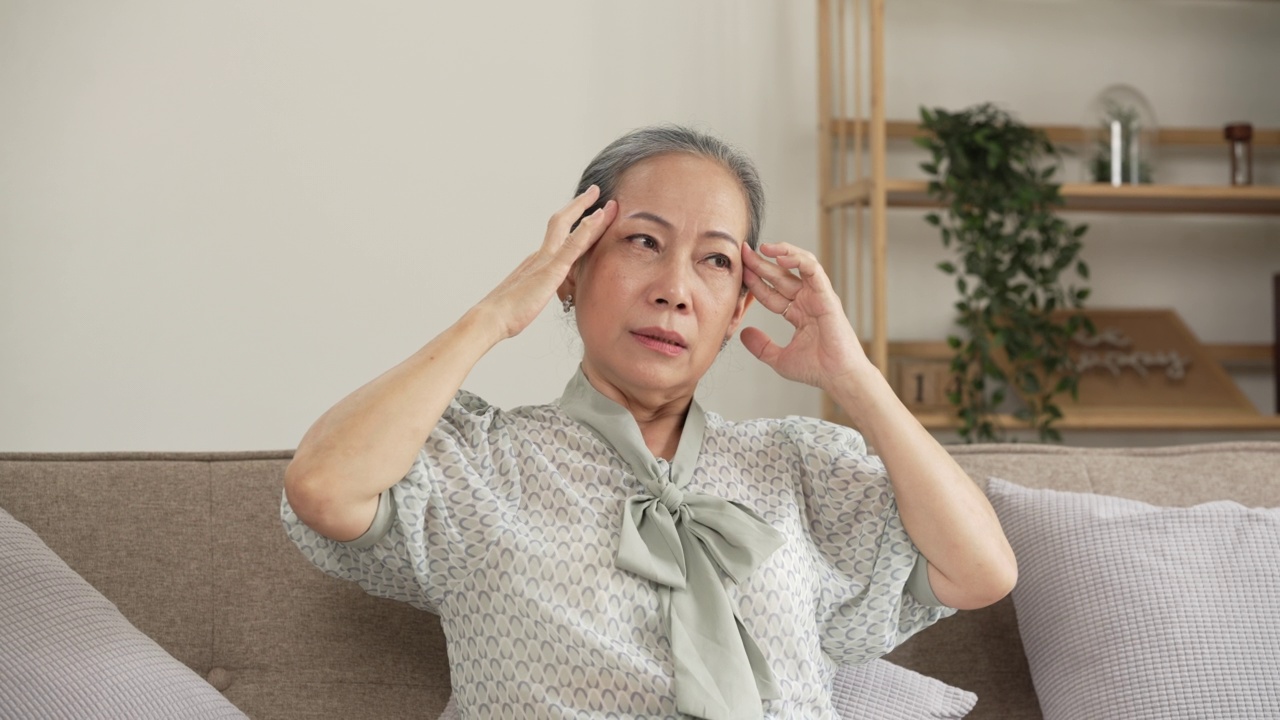 成熟的亚洲女性在家里感到头疼。视频素材