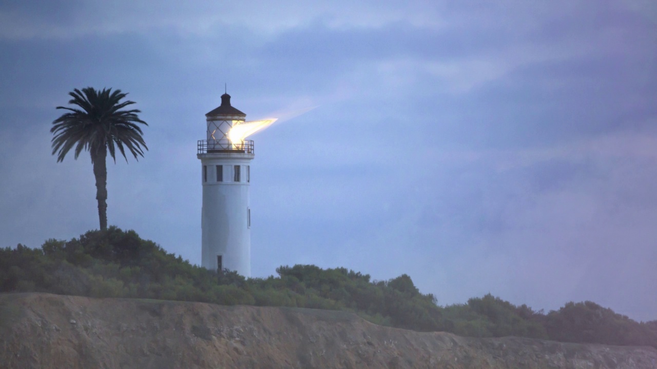 夜晚，灯塔在海岸上闪烁的灯光视频素材