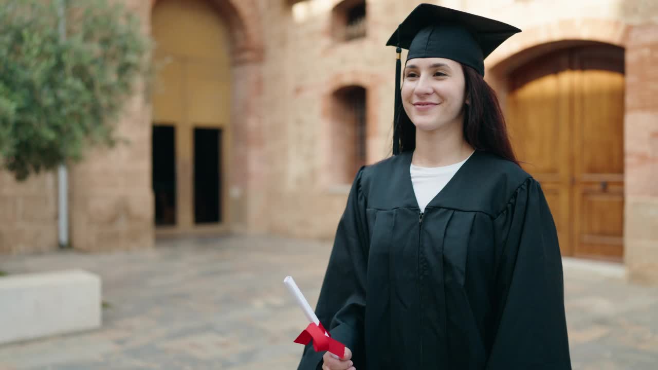 在大学校园里，两个拿着毕业证书的母女紧紧拥抱在一起视频素材