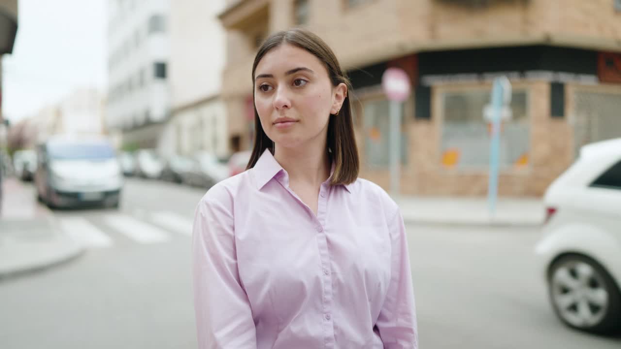 年轻的西班牙妇女站在街上微笑自信视频素材