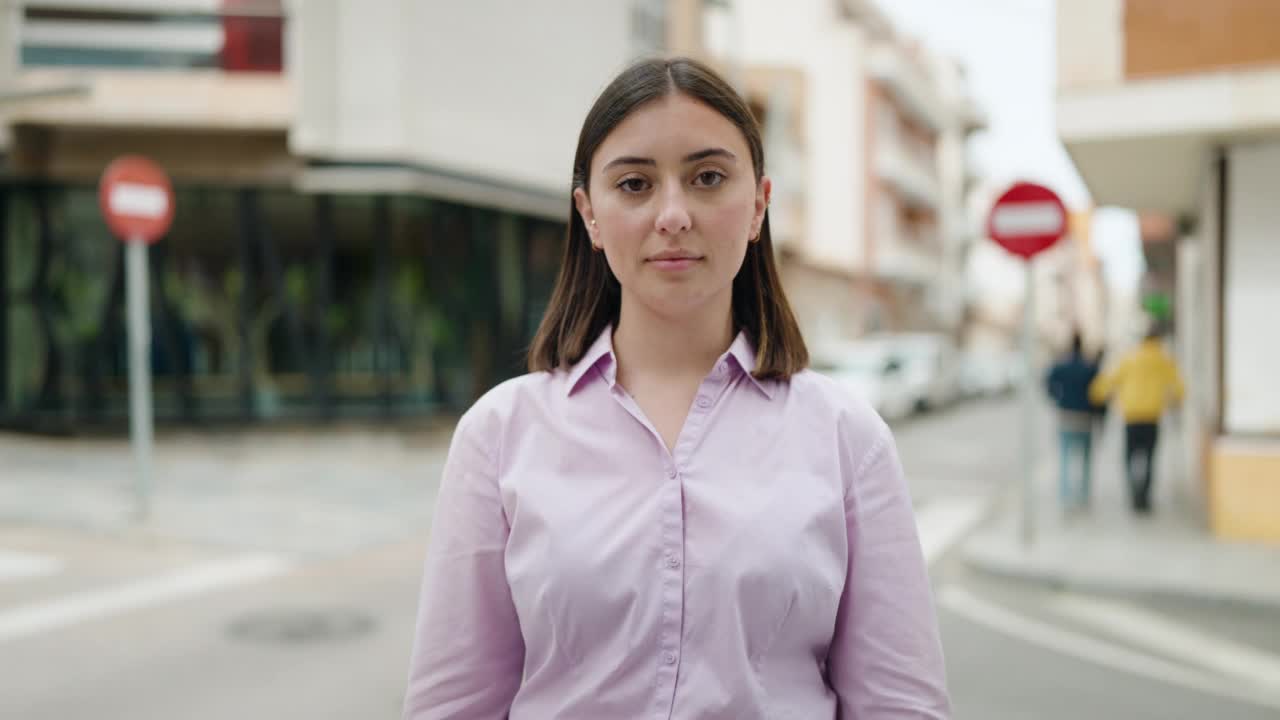 年轻的西班牙女人戴着眼镜在街上微笑自信视频素材