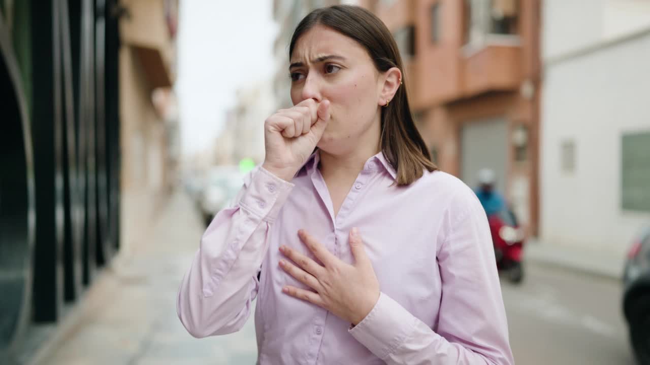 年轻的西班牙妇女在街上咳嗽视频素材