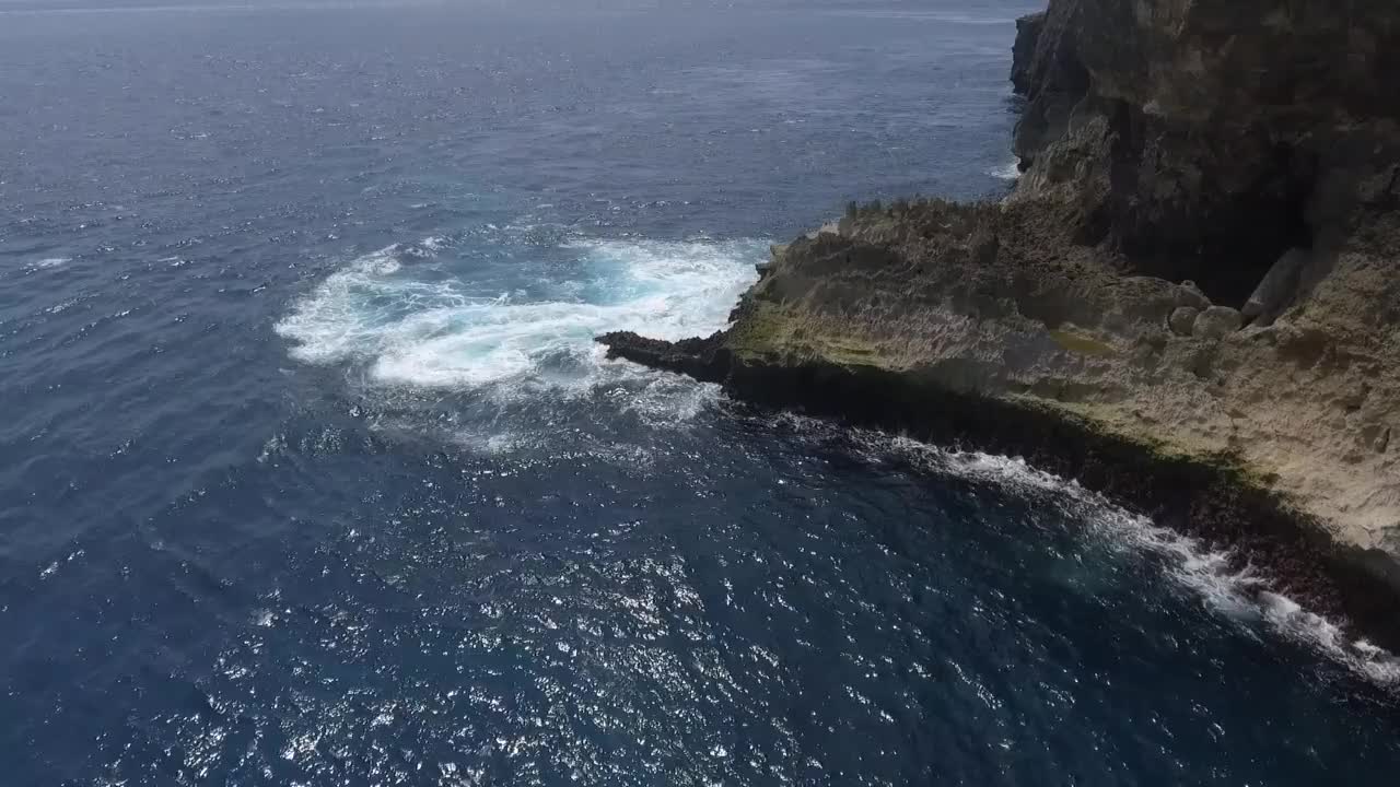 无人机拍摄的泡沫海浪在海上悬崖上翻滚和撞击视频素材