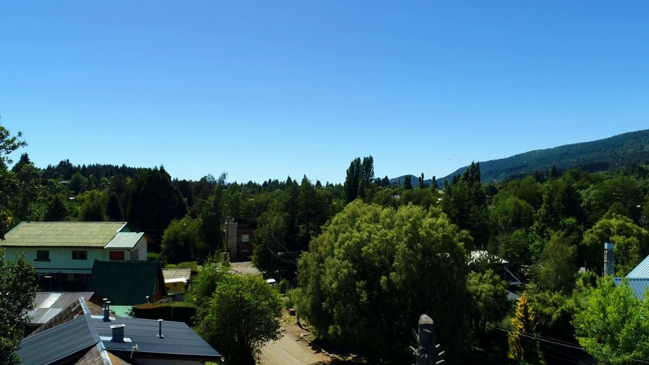 无人机拍摄的城市景观在充满树木和山的绿色领域在阿根廷视频素材