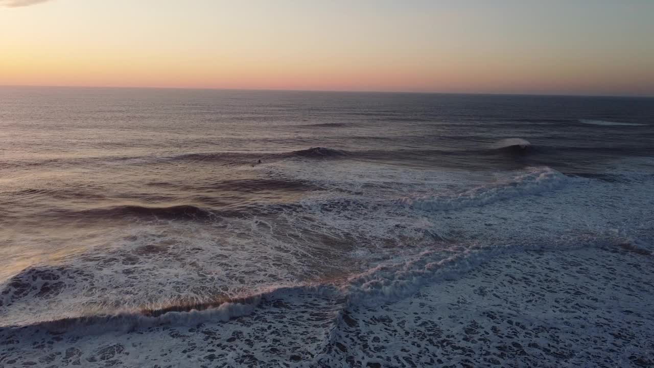 黄昏时分，航拍的巨浪翻滚在葡萄牙纳扎尔海岸视频素材