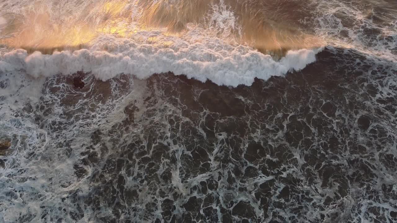 黄昏时分，航拍的巨浪翻滚在葡萄牙纳扎尔海岸视频素材